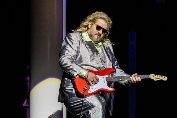 Nicola Alaimo als Sir John Falstaff spielt eine rote E-Gitarre / Copyright: Semperoper Dresden/Jochen Quast