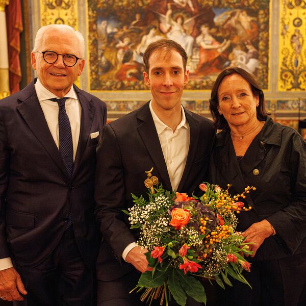 Christian Bauch mit einem Blumenstrauß zwischen Prof. Dr. Rüdiger Grube, Vorsitzender des Stiftungsrats, und Susanne Häussler